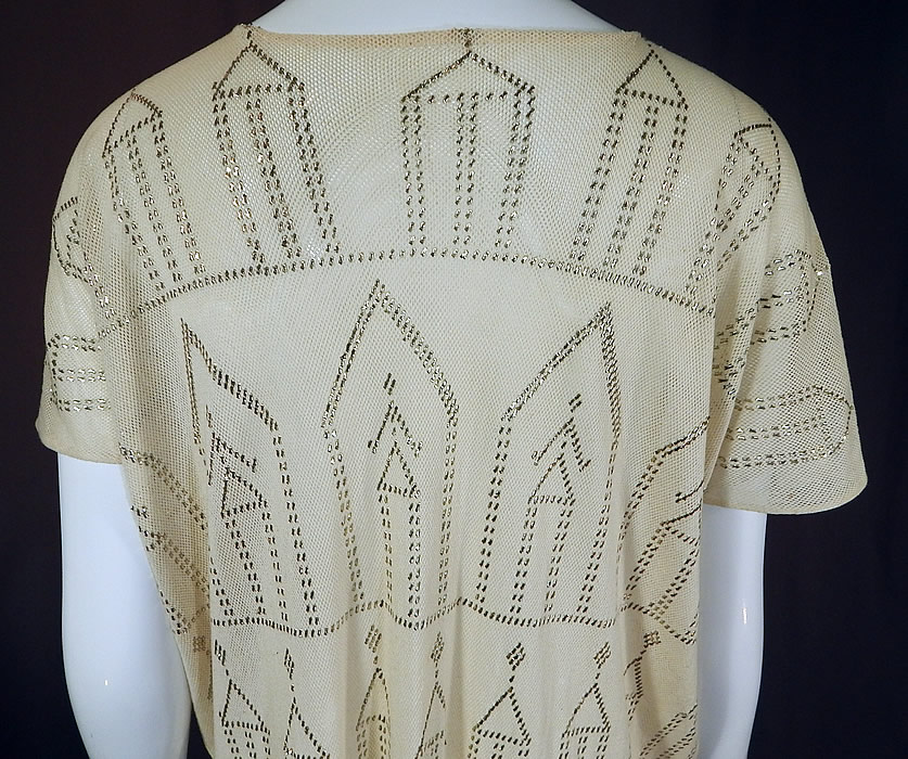Vintage Art Deco Egyptian Assuit Shawl White Net Silver Studded Tunic Mini Dress
This amazing antique Art Deco Egyptian Assuit shawl white net silver studded tunic mini dress dates from the 1920s. It is made of a white sheer cotton netting, covered with hand applied silver metal pieces done in decorative Art Deco abstract geometric designs of stick figure people, Bedouin tents and trees. Assuit shawls were made popular during the Egyptian Revival in the 1920s with the discovery of King Tut's tomb and were made in Assiut, Egypt. These Assuit shawls are also known as Tulle-bi-telli, Assuit, Asyut, Assyut, Assiut. Tulle-bi-telli translates roughly as "net with metal" and were sometimes custom made into fashionable clothing.