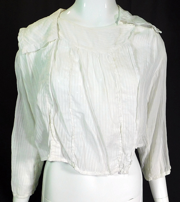 Edwardian White Cotton Batiste Striped Sailor Collar Middy Blouse Shirt
This vintage Edwardian era white cotton batiste striped sailor collar middy blouse shirt dates from 1910. It is made of a sheer white cotton batiste fabric with a woven striped pattern.