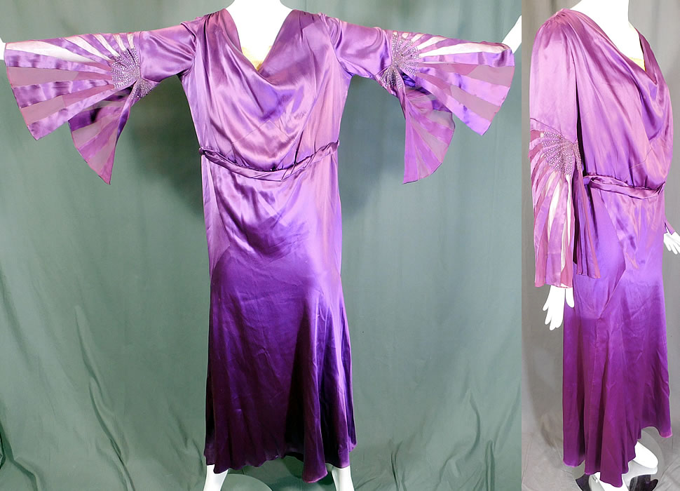 Vintage Art Deco Purple Silk Beaded Bell Sleeve Bias Cut Dress Evening Gown
This gorgeous gown is a long floor length with a bias cut style, long full flared bell shape sleeves, a cream lace trim modesty insert with weighted front neckline, back keyhole opening bow trim, an attached matching fabric belted waist and is lined inside the top only with a net camisole. 