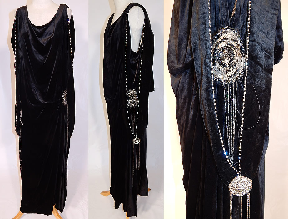 Vintage Art Deco Black Velvet Silver Rhinestone Beaded Flapper Dress Evening Gown
This vintage Art Deco black velvet silver rhinestone beaded flapper dress evening gown dates from the 1920s. It is made of a black silk velvet fabric, with silver crystal hand bead work and prong set rhinestone accents done in a floral motif design along the side. 