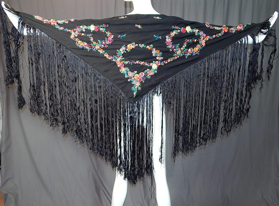 Vintage Black Silk Floral Garland Rosette Yarn Embroidered Fringe Shawl Scarf
This vintage black silk floral garland rosette yarn embroidered fringe shawl scarf dates from the 1940s. It is made of a black silk crepe fabric, with colorful yarn hand embroidery work of raised rosette garland flowers on one side and green leaf vines on the other side. 