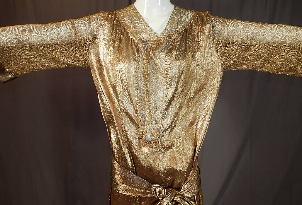 Vintage Art Deco Gold Lamé Lame Lace Belted Sash Scarf Shift Kaftan Flapper Dress
It is made of a gold metallic silk lamé damask weave brocade fabric with a woven abstract floral leaf design and sheer gold metallic lace flower pattern sleeves. 