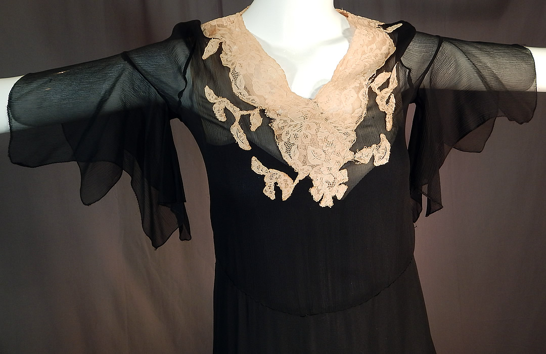Vintage Black Silk Chiffon Cream Lace Handkerchief Sleeve Bias Cut Dress Slip
This beautiful black bias cut dress is a shorter mid length, with a side tiered layered ruffle skirt, lace trim V front neckline, fluttery handkerchief style short sleeves, side snap closures and is sheer, unlined. 