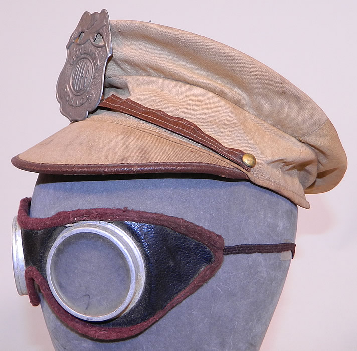 Vintage Childrens Juvenile Police Chief Toy Tin Badge Cap Hat & Motorcycle Goggles
Included in the child's dress-up toy play set is an off white ecru cream color cotton fabric cap hat with brim, leather trim edging and a silver tone tin metal "Juvenile Police Chief" badge. 