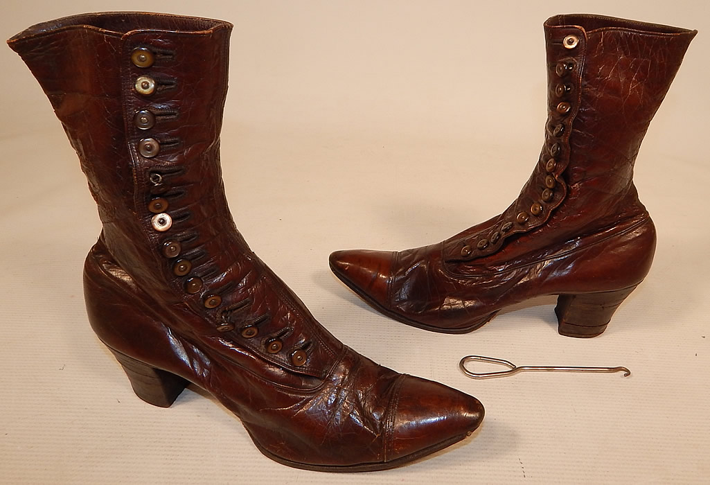 Victorian Antique Women's Brown Leather High Top Button Boots Shoe Hook
This pair of antique Victorian era women's brown leather high top button boots and shoe button hook date from 1900. They are made of a supple dark brown leather, with decorative punch work trim across the front toes.