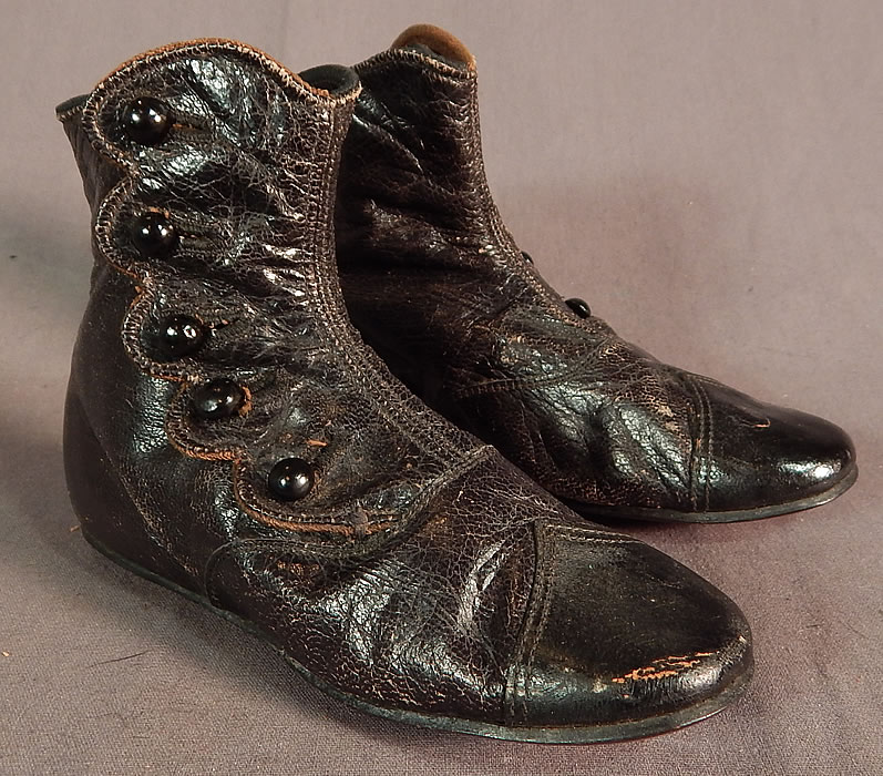 Unworn Victorian Black Leather High Button Baby Boots Childs Shoes
This pair of antique Victorian era unworn black leather high button baby boots child's shoes date from 1870. They are made of a black leather, with 5 black shoe buttons down the scalloped sides for closure.