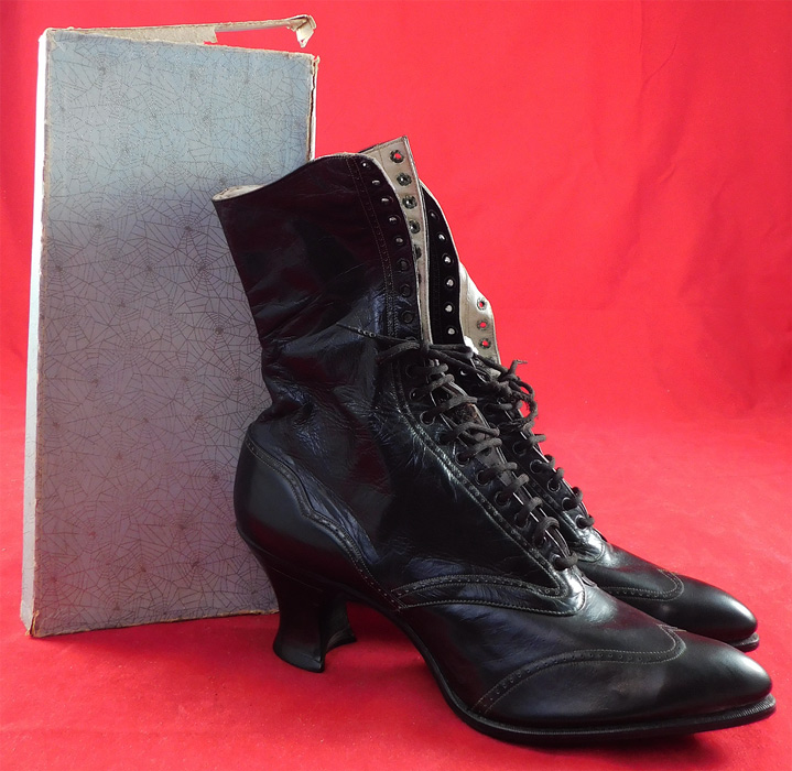 Unworn Edwardian Black Kid Leather High Top Lace-up Boots & Shoe Box
This pair of unworn antique Edwardian era black kid leather high top lace-up boots and shoe box dates from 1910. They are made of a supple black kid leather with decorative punchwork and stitched designs. These beautiful black boots have pointed toes, the original black shoe string laces which are frayed, stacked wooden black spool French heels and black bottom leather soles. 