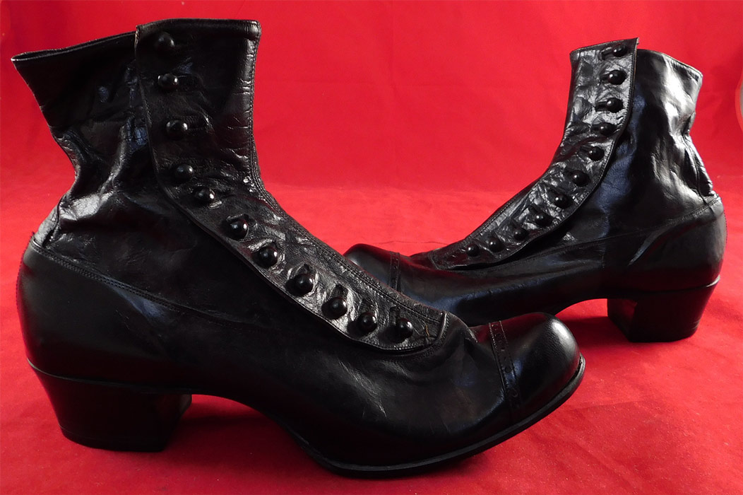 Victorian Unworn Womans Black Kid Leather High Top Button Boots
These beautiful boots have bulbous rounded toes with decorative punch work designs, 11 black shoe buttons along the side for closure and stacked black wooden cube heels. 