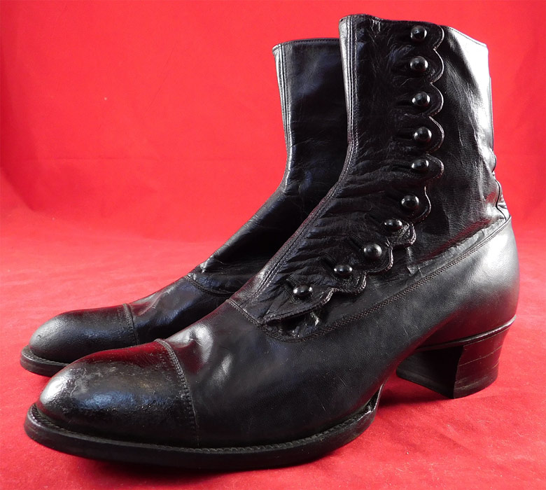 Victorian Unworn Womens Black Leather High Top Button Boots
These beautiful boots have rounded bulbous toes, decorative scalloped side edging with 10 black shoe buttons for closure, stacked wooden black cube heels and blue silk lining inside the top. The boots measure 7 inches tall, 9 inches long, 3 inches wide, with 1 1/2 inch high heels. 