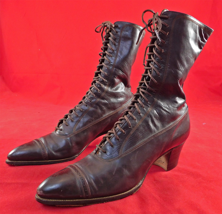 Victorian Unworn Poehlman Shoe Co. Brown Leather High Top Lace-up Boots
This pair of unworn antique Victorian era Poehlman Shoe Co. brown leather high top lace-up boots date from 1900. They are made of a dark brown leather with decorative punch work designs.