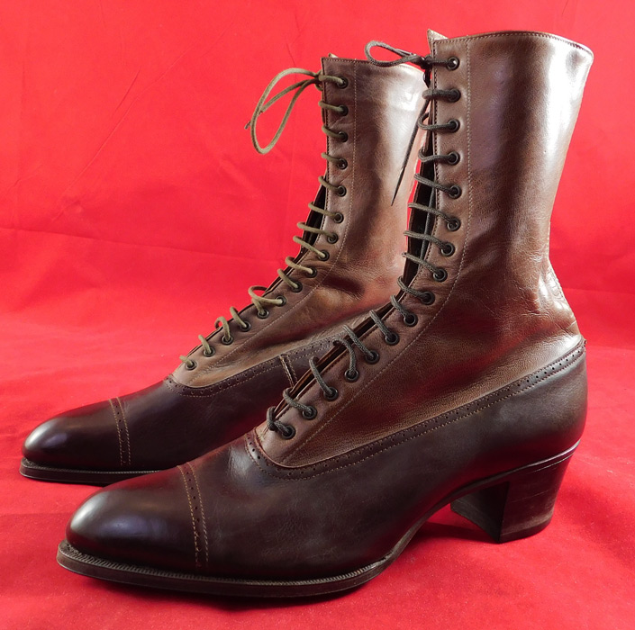 Victorian Unworn Two Tone Brown Leather High Top Lace-up Boots Cube Heels
This pair of unworn antique Victorian era two tone brown leather high top lace-up boots date from 1900. They are made of a two tone brown leather with decorative punch work designs. These beautiful boots have pointed toes, the original khaki green color shoe string laces for closure and stacked wooden cube heels.