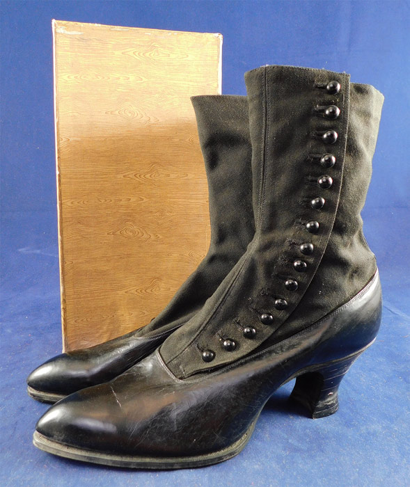 Unworn Edwardian Black Cloth Top Kid Leather High Button Boots & Shoe Box
These womens beautiful black boots have pointed toes, 15 black shoe buttons along the side for closure and black stacked wooden French spool heels. They come in the original shoe box covered with a decorative woodgrain knot graphic print paper from "The Harris Shoe Store" in Dover, New Jersey and are stamped on the outside of the box a European size 38. The boots measure 9 1/2 inches tall, 10 inches long, 2 3/4 inches wide, with a 2 1/2 inch high heel and are approximately a US size 7 or 8 narrow width. 