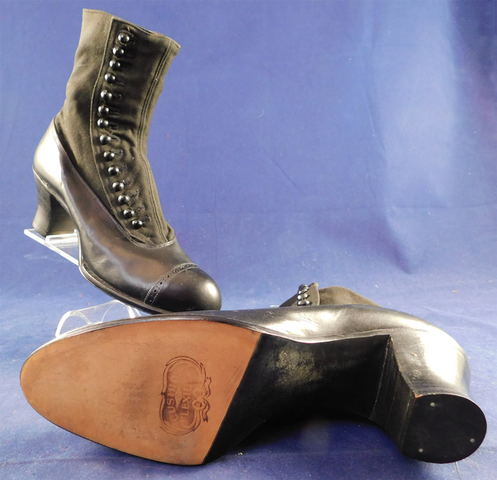 Unworn Edwardian Gunmetal Gray Black Leather Cloth High Top Button Boots & Shoe Box
This pair of unworn antique Edwardian era gunmetal gray black leather cloth high top button boots and shoe box date from 1910. They are made of a gunmetal gray blackish color leather shoe and cloth fabric upper boot. These womens beautiful black boots have rounded toes, 14 black shoe buttons along the side for closure, black stacked wooden cube heels and are stamped "Cushion Flexible" on the bottom leather soles.
