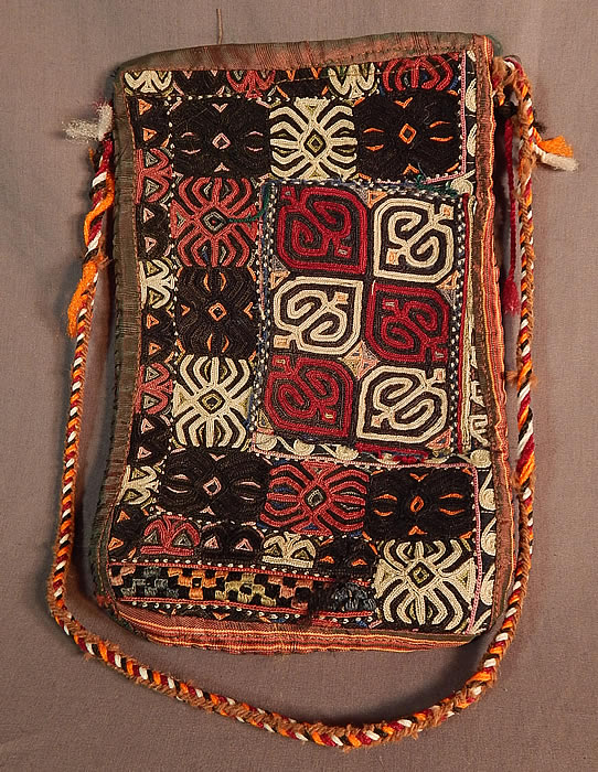 Vintage Afghan Uzbek Lakai Embroidery Tribal Ethnic Boho Bedouin Pouch Purse
This unique custom made pouch purse bag is a fusion of ethnicities from Central Asia, with Afghan, Uzbek Lakai embroidery on the outside and former Soviet Union Russian red roses floral print cotton fabrics lining the inside. This stunning handmade hand embroidered nomadic bedouin boho gypsy style bag has a colorful braided rope strap, an iridescent silk trim edging and open top with no closure.