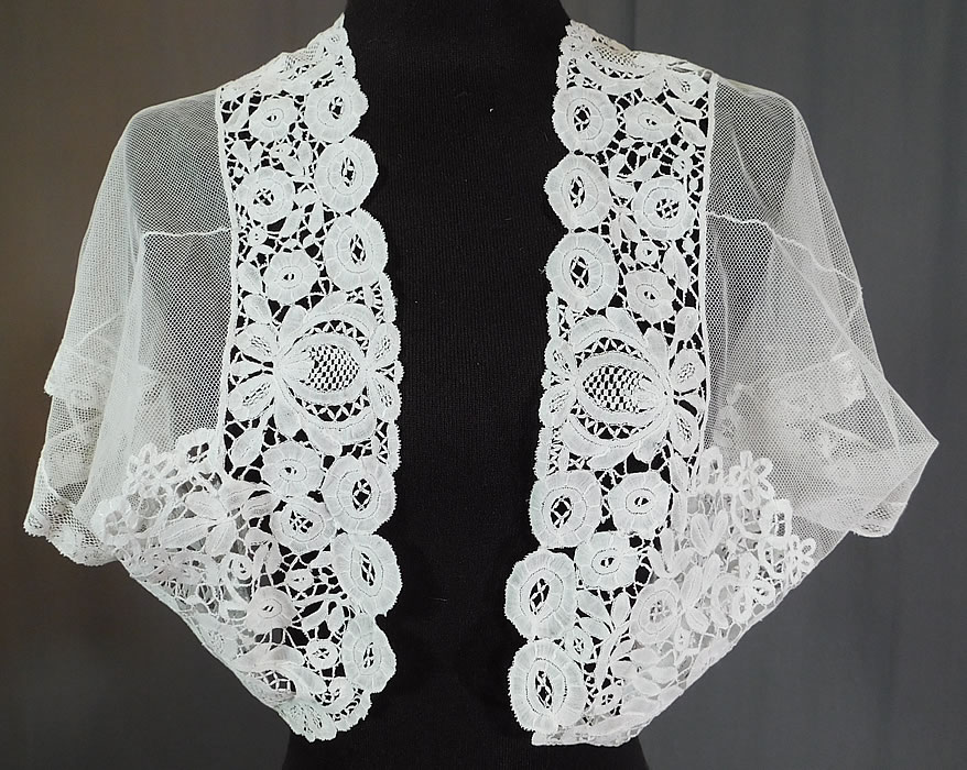 Edwardian White Net Duchesse Bobbin Tape Lace Bolero Jacket Shrug Top
This Edwardian era antique white net duchesse bobbin tape lace bolero jacket shrug top dates from 1910. It is made of a sheer white net with filmy linen half stitch, veined flowers and leaves, joined by braided plaits and Valenciennes lace trim cuffs edging