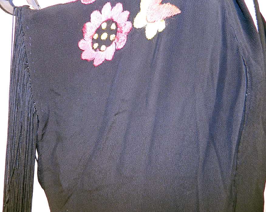 Vintage Art Deco Black Silk Floral Embroidered Piano Shawl Long Robe Coat. This lovely long loose fitting kimono robe style coat is floor length, with an open front, no closure, sleeveless with long black silk fringe trim edging around the arm holes and is unlined.