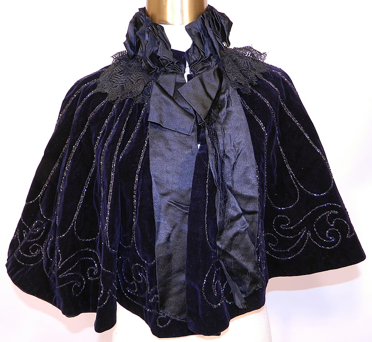 Victorian Black Velvet Jet Beaded Evening Opera Cloak Cape Capelet. This antique Victorian era black velvet jet beaded evening opera cloak cape capelet dates from 1880. It is made of a black velvet fabric, with black jet bead work done in a decorative scalloped scroll work design. 