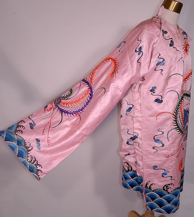 Antique Chinese Pink Silk Embroidered Phoenix Bird Opera Robe Coat. This beautiful theatrical opera robe style coat is a long mid length, loose fitting, with long exaggerated full sleeves, silk ties for closure along the side and is fully lined. The robe measures 40 inches long, with 50 inch hips, a 50 inch waist, 42 inch chest and 26 inch long sleeves. 