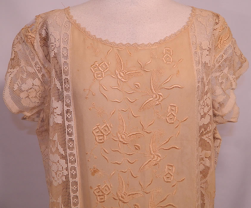 Vintage Cream Silk Butterfly French Knot Embroidered  Filet Lace Drop Waist Dress. It is made of an off white cream color fine silk fabric, with raised padded satin stitch and French knot embroidery work done in a floral butterfly design and filet lace inserts done in a floral rose vine leaf pattern.