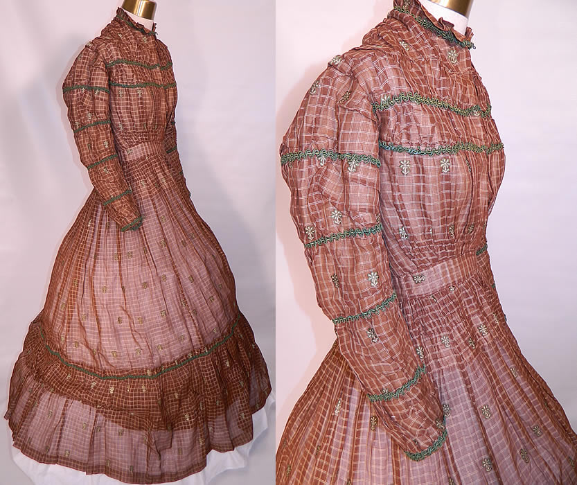 Victorian Civil War Brown & White Plaid Muslin  Green Floral Trim Embroidered Dress. This beautiful dress has a ruffled high neckline, long sleeves with green trim spaced gathering going down to the cuffs, smocking gathers around the fitted waistband, a long full hoop skirt with layered lined bottom ruffle, linen lined bodice and hook closures down the front.