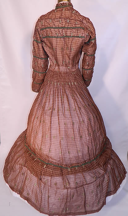 Victorian Civil War Brown & White Plaid Muslin  Green Floral Trim Embroidered Dress. The dress measures 55 inches long, with a 26 inch waist, 32 inch bust, 12 inch back and 20 inch long sleeves. 