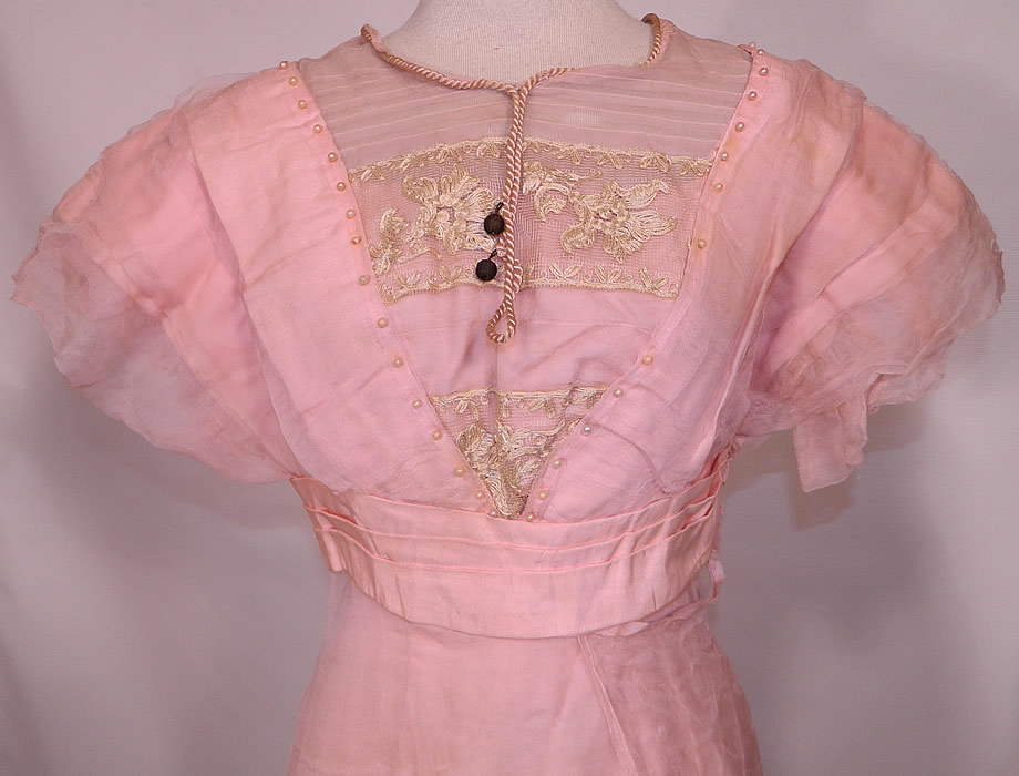 Edwardian Titanic Pink Silk Pearl Beaded Lace  Evening Gown Dress. This pretty pink evening ball gown dress has a long floor length layered asymmetrical skirt, a pleated layered trim top, short sleeves, pink back bow trim belted sash waist, hook closures on the back and is fully lined.