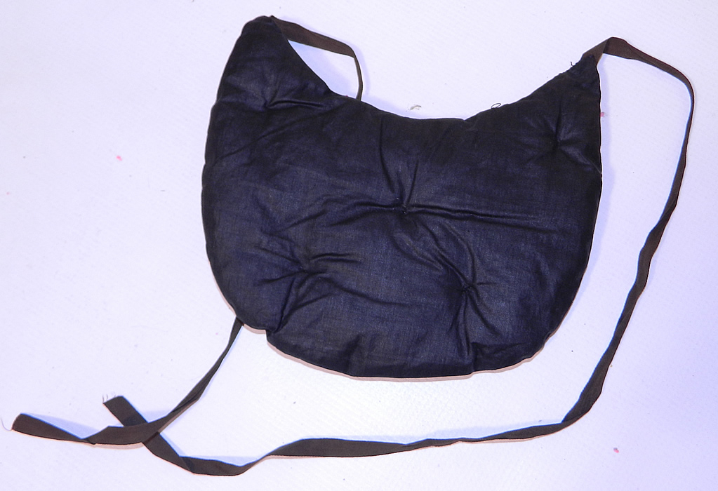 Victorian Quilted Horse Hair Black Polished Cotton Crinolette Bustle Pad Support. There is a linen cloth strap tie belt around the waist. This unique undergarment would have been worn under a bustle skirt dress to expand the fullness or support the back drape of the fanned train skirt.