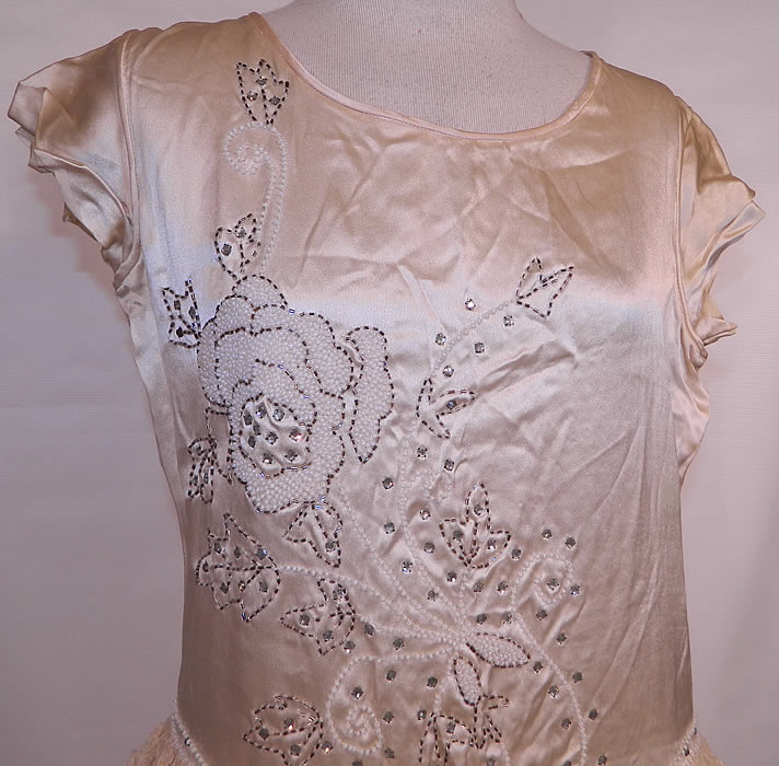 Vintage Robe de Style Cream Silk Rhinestone Beaded Lace Pannier Hoop Wedding Dress. It is made of an off white ivory cream color silk fabric, with crystal silver, white, rhinestone beading done in a floral rose leaf pattern design on the top. 