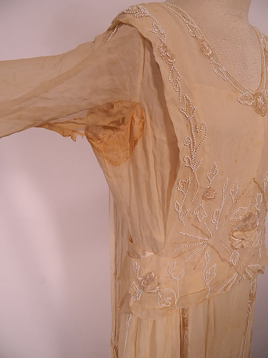 Edwardian Cream Silk White Beaded Rosette Belted Wedding Gown Dress. It is in as-is fair condition, has not been cleaned, with several small faint age spots yellowing stains in areas and frayed stained underarms (see close-up).