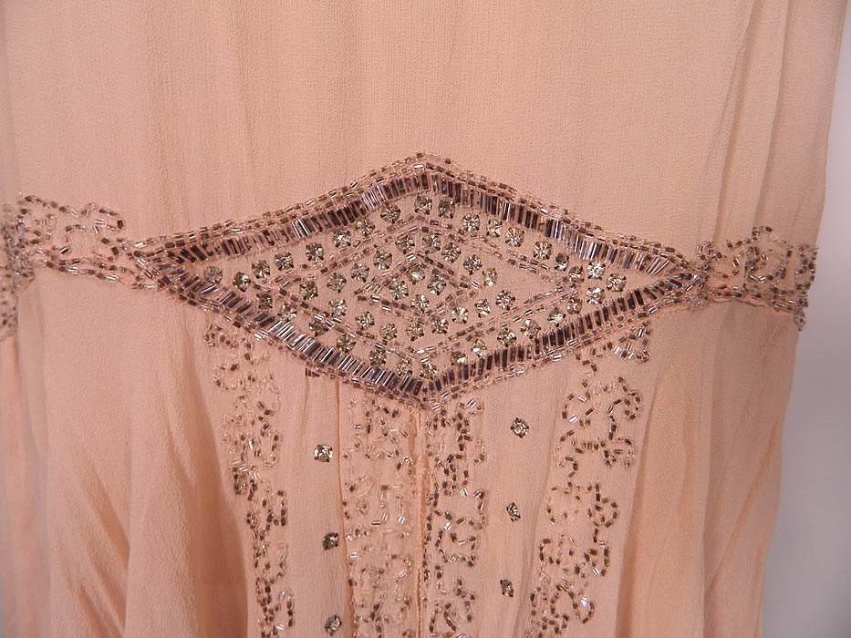 Vintage Art Deco Pink Silk Rhinestone Silver Beaded  Flapper Dress. The dress measures 44 inches long, with 38 inch hips, a 38 inch waist and 38 inch bust. It is in good condition, but has not been cleaned, with a  few tiny faint age spot stains on the front top and some yellowing discoloration on the back. This is truly a wonderful piece of Art Deco wearable beaded textile art! 