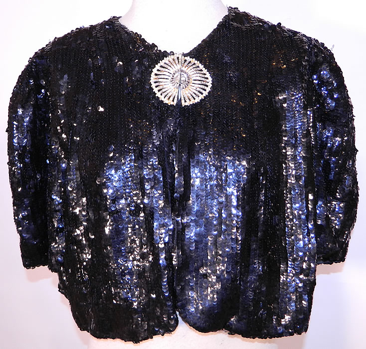 Vintage Black Sequin Beaded Rhinestone Clasp Cropped Bolero Evening Jacket. This vintage black  sequin beaded rhinestone clasp cropped bolero evening jacket dates from the 1940s. It is made of a completely covered  black sequin beading, with a large Art Deco rhinestone buckle clasp closure. 