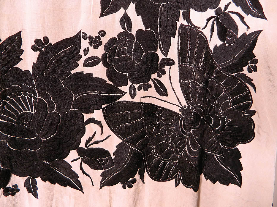 Antique Black & White Floral Butterfly Silk Embroidered Canton Piano Shawl. There is a fabulous floral rose, dragonfly embroidered border with a large beautiful butterfly embroidered in each corner. There is a hand knotted macramé black silk fringe which measures 24 inches long surrounding the entire shawl with rounded corners.