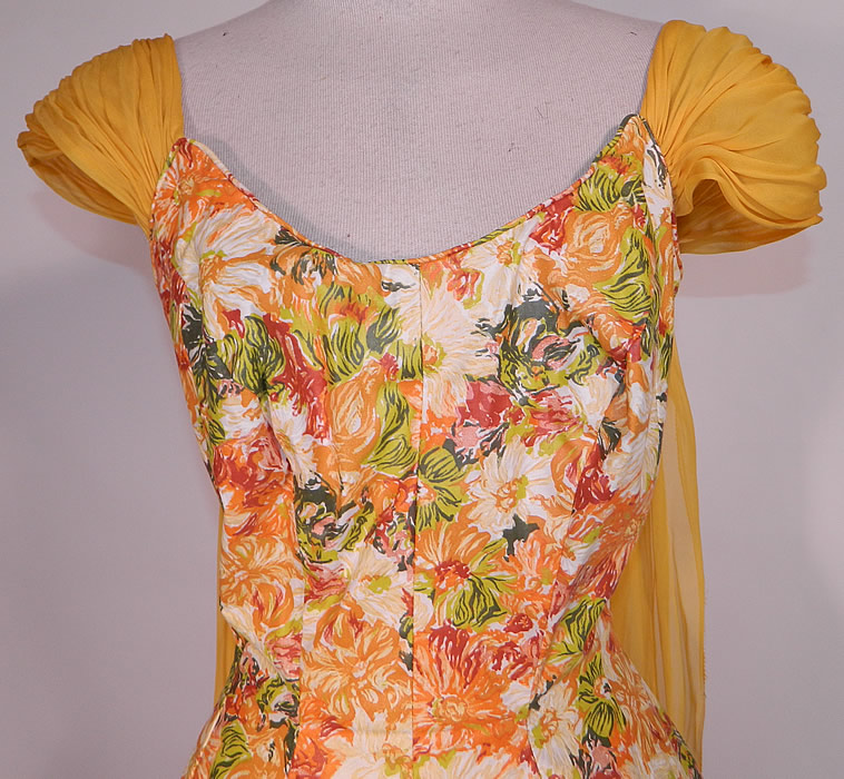 Vintage Edson's Hotel Syracuse Yellow Chiffon Scarf Floral Print Cotton Circle Skirt Dress. There is a golden yellow color silk chiffon pleated cap sleeve and long scarf drape down the back. This sensational summer dress has a low scoop neckline, short cap sleeves, fitted waist, full circle skirt and back zipper closure.