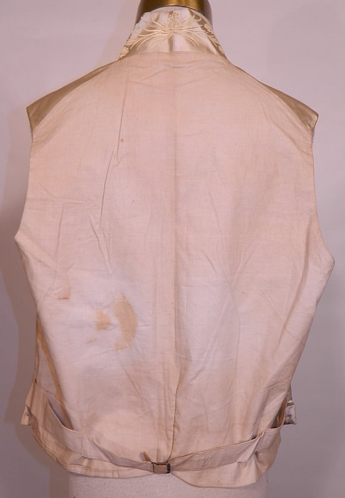 Victorian Gentlemen's White Silk Damask Floral Brocade Wedding Waistcoat Vest. There is a linen fabric backing, with an adjustable metal buckle, strap on the lower back. It is lined in linen.It is in good condition, with only slight underarm discoloration, a small repair on the lower back and some faint age spotting on the back fabric (see close-up). This is truly a quality made men's early Victorian vest!