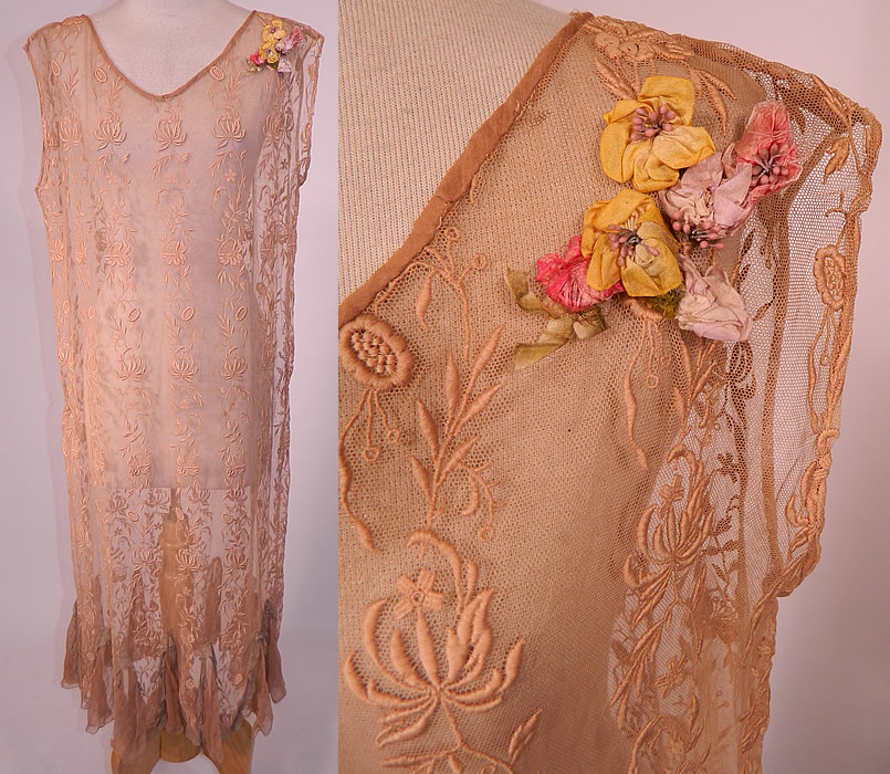 Vintage Ecru Embroidered Net Lace Silk Rosette Chemise Shift Slip Dress. 
This vintage ecru embroidered net lace silk rosette chemise shift slip dress dates from the 1920s. It is made of an ecru beige cream color sheer net fabric with raised padded satin stitch embroidery work done in a floral vine leaf pattern.