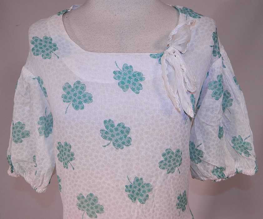 Vintage Green Shamrock Clover Print White Cotton Bias Cut St. Patricks Day Dress
This delightful St. Patrick's day dress has a fitted bias cut, lace trimmed bow tie on the neckline, gathered smocking along the shoulders, short puffy sleeves and is sheer, unlined. 