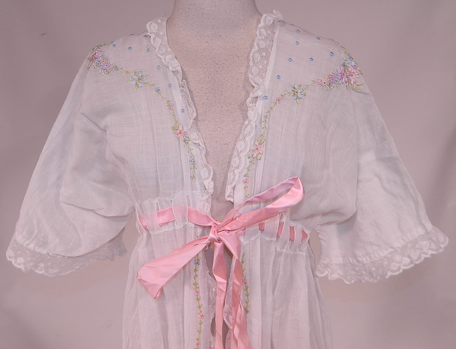 Edwardian Titanic White Cotton Rosette Embroidered Lace Peignoir Dressing Gown Robe
This beautiful boudoir peignoir robe dressing gown is loose fitting, a long floor length with a high empire waist, pink silk ribbon woven belted tie sash front closure and full short sleeves.