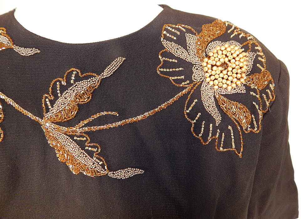 Vintage Eisenberg Originals Black Silk Crepe Gold Flower Beaded Cocktail Dress
This beautiful beaded cocktail dress has broad shoulder padding, short sleeves, a fitted waist with side tie belted sash, a long mid length skirt and back zipper closure. 