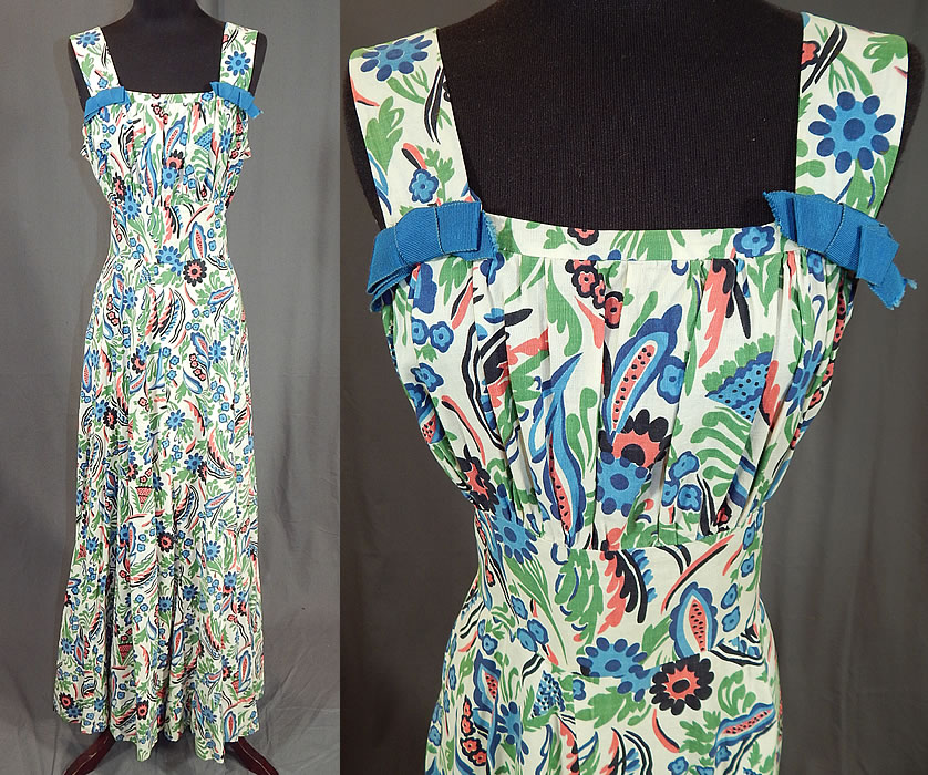 Vintage Colorful Cotton Floral Leaf Print Maxi Dress & Cropped Bolero Jacket
This stunning summer sun dress has a long floor length maxi style with full skirt, shoulder straps with blue ribbon bow trim accents, squared necklines, a fitted waist, side snap, hook closures and is unlined. The dress measures 58 inches long, with a 30 inch waist and 36 inch bust. 