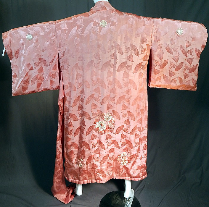 Vintage Japanese Pink Silk Damask Fan Floral Embroidered Mon Belted Kimono Robe
This pretty pink Japanese kimono robe has a white embroidered butterfly medallion mon emblem family crest on both the front and back top, is fully lined with inside pocket, full kimono sleeves, a rolled padded hem and matching fabric tie sash belt for closure. 