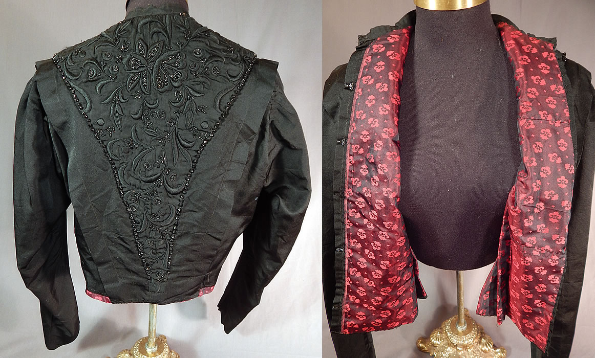 Victorian Black Silk Embroidered Jet Beaded Bodice Coat Jacket
This beautiful black beaded bodice coat jacket has a fitted tailored style, with the embroidered bead work done along the front and back V panels, has long sleeves, a band collar, hook closure down the front and is fully lined in a red and black floral pattern iridescent silk damask weave fabric inside. 