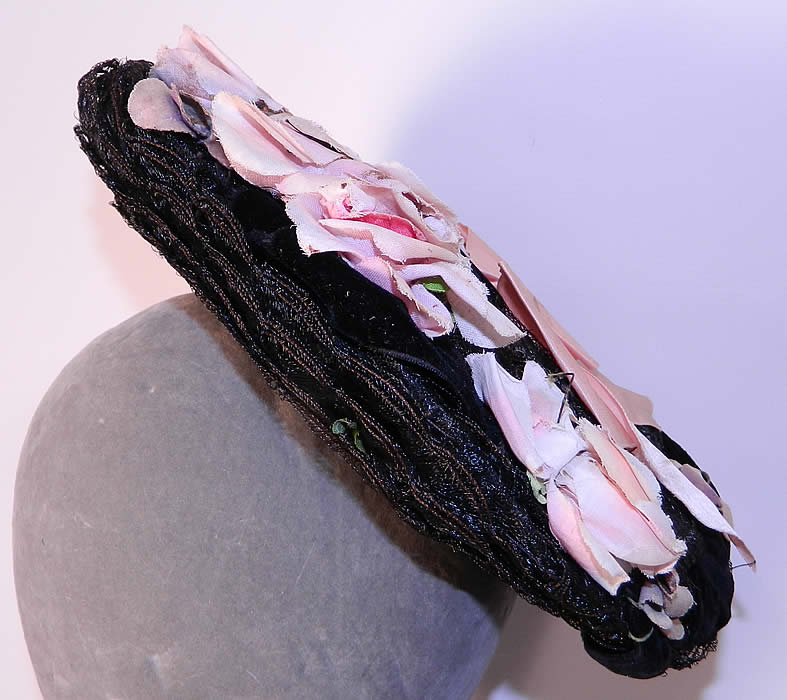 Victorian Black Straw Pink Pansy Rose Flower Bow Trim Bonnet Flat Plate Hat. It is made of a woven black straw wire frame base, with black velvet ribbon, pink pansy, rose flowers and a pink bow trim on top.