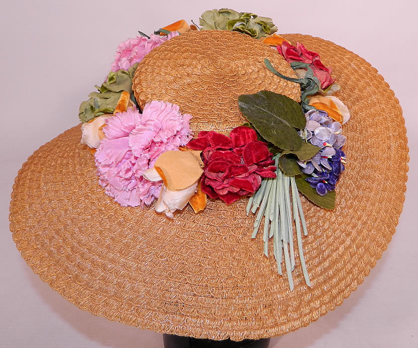 Vintage Woven Natural  Straw Silk Velvet Flowers Wide Brim Summer Cartwheel  Hat.  It is made of a tightly woven natural straw, with a colorful floral hatband made of a variety of silk, velvet flowers encircling the crown.