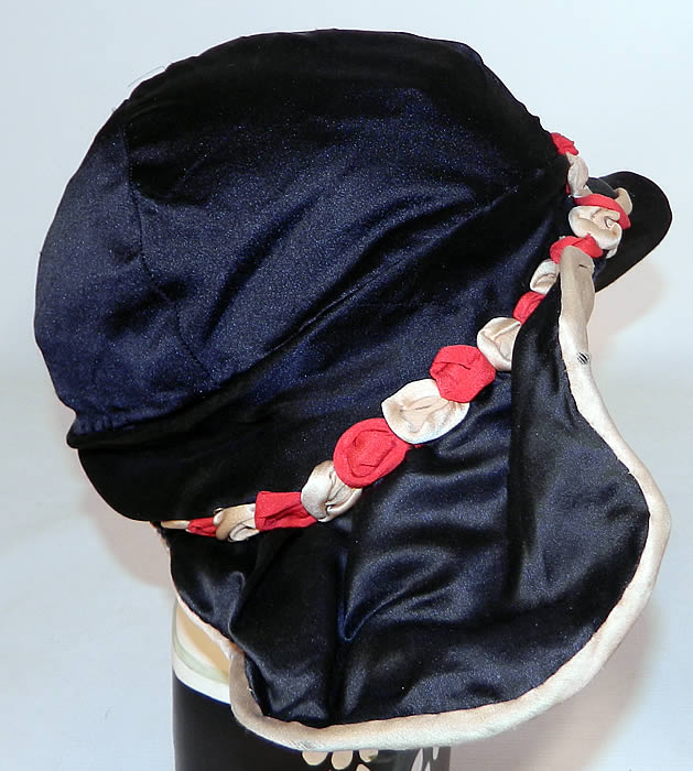 Vintage Art Deco Black & White Silk Red Rosette Wired Wing Brim Flapper Cloche Hat. The hat measures 24 inches inside crown circumference. 