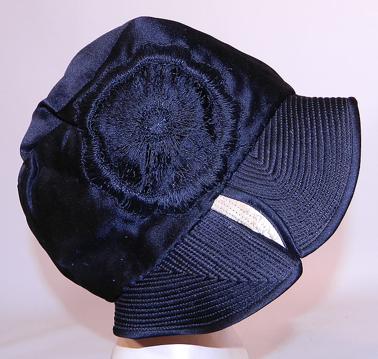 Vintage Marcelle Hats Art Deco Black  & White Silk Rosette Quilted Brim Flapper Cloche. It is made of a black silk satin fabric, with a black and white quilted stitched brim and black silk rosette embroidered applique trim on the side.