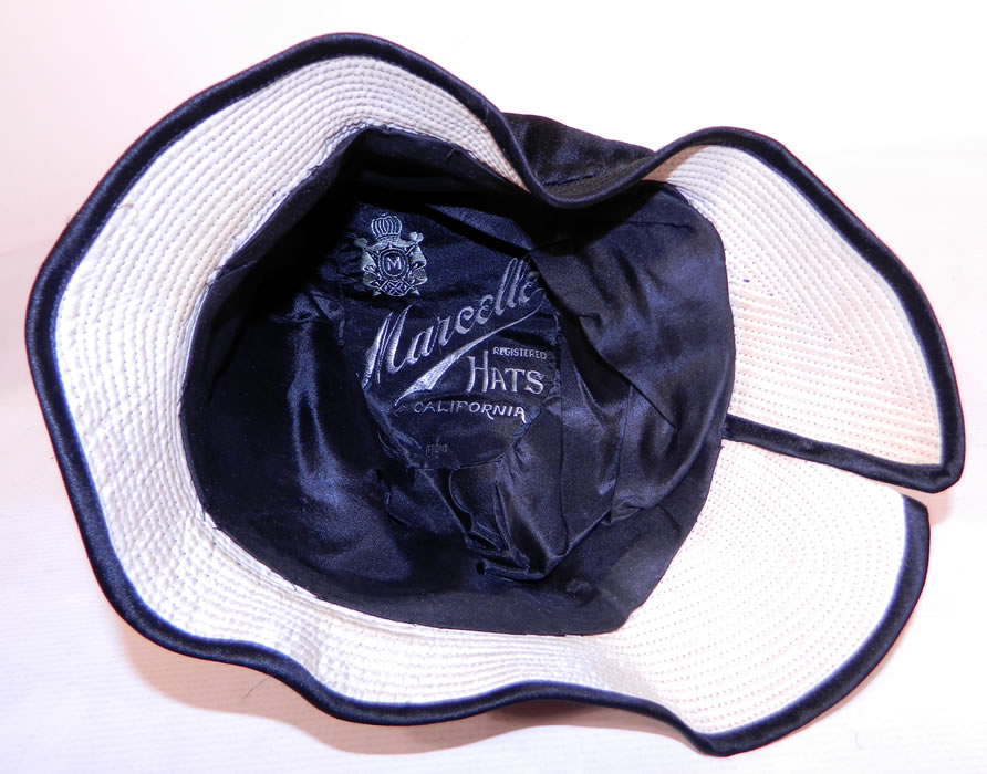 Vintage Marcelle Hats Art Deco Black  & White Silk Rosette Quilted Brim Flapper Cloche. It is fully lined in silk and has a "Marcelle Hats California" label inside. 