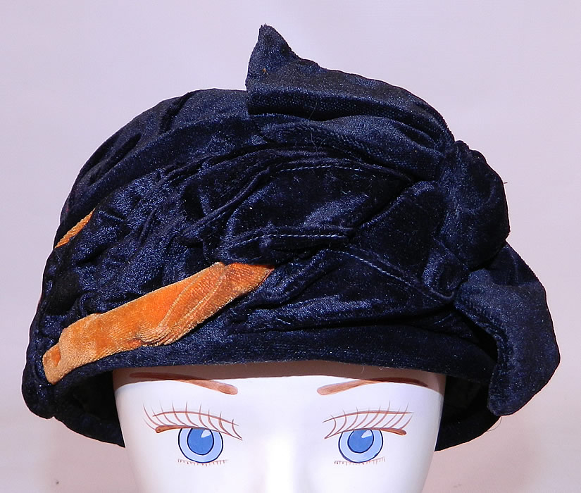 Vintage Art Deco Black & Orange Velvet Knotted Bow Trim Flapper Cloche Hat. The hat is made of black and orange silk velvet fabric, with a draped, wrapped design around the outside and a knotted bow trim on the front.