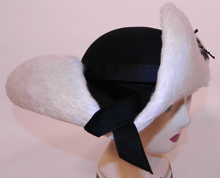 Vintage Leon Hats NY Label Black & White Felt Fur Jet Beaded Trim Tricorn Hat
This unique updated reproduction of an 18th century style tricorn hat has a three cornered upturned rolled brim and small rounded top crown, with elastic strap attached underneath to secure onto the head. 