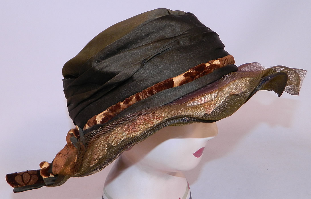 Vintage Brown Silk Voided Velvet Pink Flower Trim Wide Brim Cloche Hat
This fabulous flapper cloche style hat has a form fitting style, with an uneven asymmetrical wavy brim which is wider on the sides and is fully lined inside the crown in black silk. 