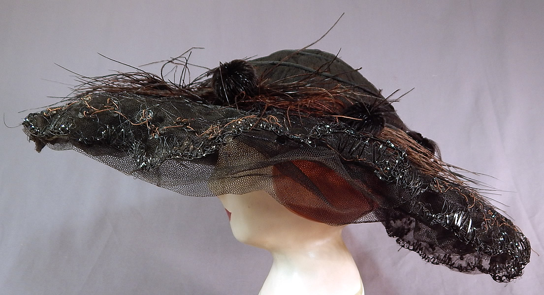 Edwardian Black Tulle Net Sequin Feather Trim Large Wired Wide Brim Hat
It is made of a black sheer tulle net fabric covering a wired brim with black straw stitching edging.